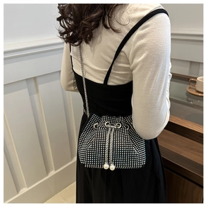 Detail der Strass-Beuteltasche mit Perlen-Kordelzug und Metallkette an einem Modell