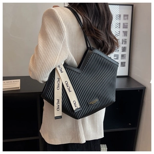 Detailed shot of a black vertical pleated tote bag with chic canvas brand ribbon detail