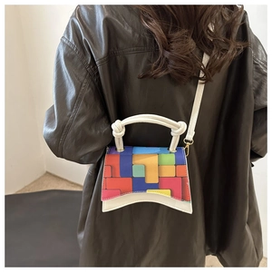 Detail of colorful geometric pattern crossbody bag worn by a model in leather jacket