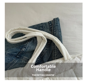 Close-up of white quilted tote bag handle featuring soft padded texture and blue denim detail