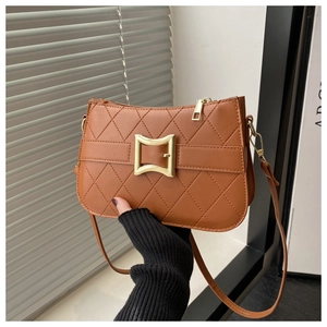 Détail de la texture en cuir matelassé marron avec boucle carrée dorée et bandoulière