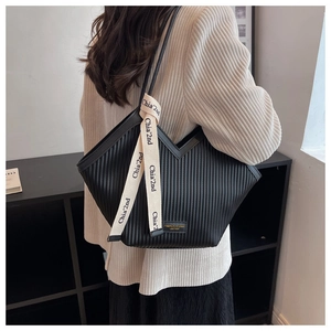 Detailed back view of a large black tote bag featuring vertical pleated textures and chic straps