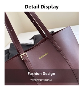 Détail d'un sac cabas bordeaux en cuir grainé avec boucle en métal et logo doré