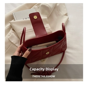Detail showing the inner capacity of the brown quilted leather shoulder bag with gold buckle