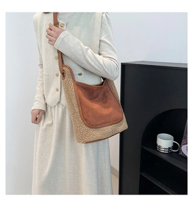 Détail montrant le contraste du daim marron et de la laine d'agneau sur le sac seau
