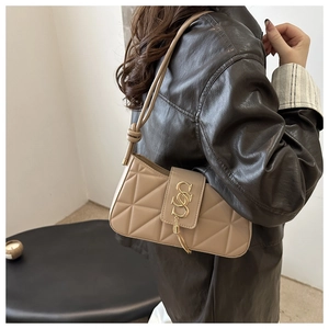 Detail of light brown quilted underarm bag with gold S-shaped buckle and fine tassel