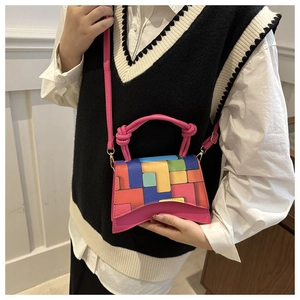 Detail view of pink crossbody bag with colorful geometric patterns and stylish curved base