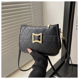 Détail du sac bandoulière matelassé noir avec boucle dorée carrée et finitions de luxe