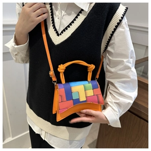 Close-up of bright orange mini hourglass handbag with colorful geometric pattern