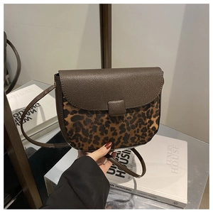 Detail of retro saddle bag featuring leopard print texture and dark brown leather flap