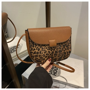 Detail of leopard print patchwork and brown lychee grain PU leather on a shoulder bag