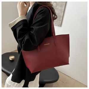 Gros plan du sac cabas bordeaux en cuir de qualité avec lettrage doré élégant