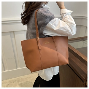 Détail d'un sac cabas marron avec lettrage doré élégant et fines bretelles doubles
