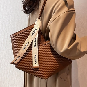 Vertical pleated dark brown tote bag with white canvas strap and elegant heart shape design