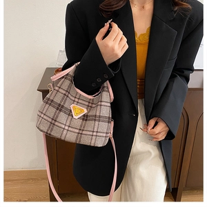 Detail of British plaid tote with pink trim and triangular metal logo ornament