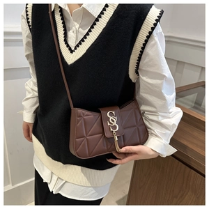 Detail of a brown quilted leather crossbody bag with a gold S-logo and metal tassel