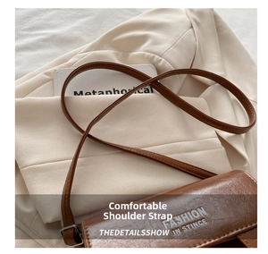 Detail of deep brown saddle bag with vintage oil-leather texture and fine shoulder strap