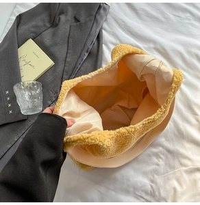 Detail shot of a yellow plush tote bag showing spacious fabric lining and soft texture