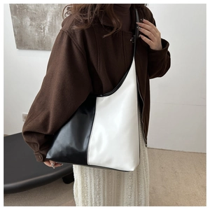 Detail view of large leather tote bag with elegant black and white vertical color blocking