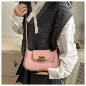 Close-up of pink baguette bag featuring a signature gold chocolate-shaped metal buckle