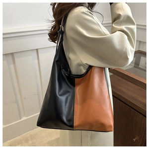 Detail of color block tote bag in black and caramel leather with wide shoulder strap
