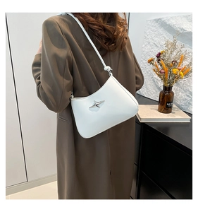 Detalle del bolso de hombro blanco con una hebilla metálica en forma de estrella