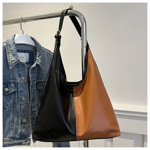 Detail of contrast stitch large tote bag in black and caramel matte faux leather finish