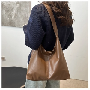 Detail view of large capacity brown PU leather tote bag with wide shoulder strap design