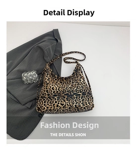 Close-up of leopard print shoulder bag with gold hardware on a grey suit background