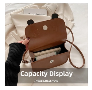 Detailed interior view of brown saddle bag showing capacity for phone and wallet