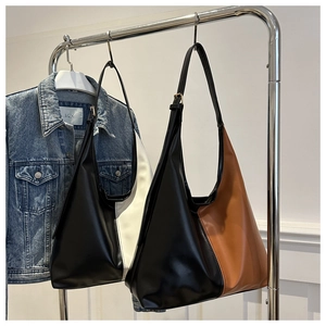 Detail view of large contrast-color PU leather tote bags in black-white and black-brown
