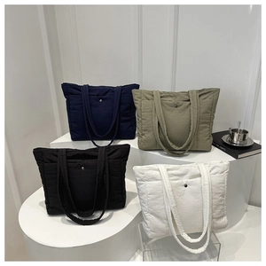 Quilted tote bags in various colors displayed on geometric stands for commute