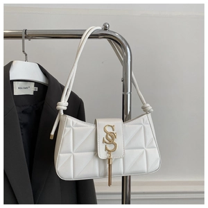 Detail of white quilted leather underarm bag with gold S-buckle and elegant fringe tassel