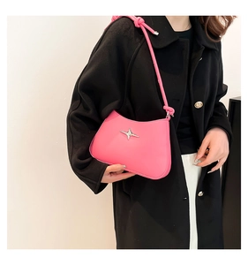 Detalle de bolso rosa con adorno de estrella plateada y correa con nudo de moda