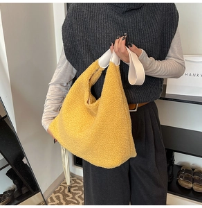 Detail of yellow fleece tote bag with wide white shoulder strap and soft plush texture