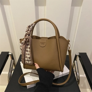 Brown lychee leather bucket bag with top handles and stylish checkered ribbon decor