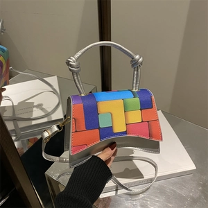 Silver metallic leather handbag with colorful geometric pattern and twisted top handle