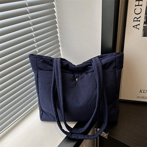 Deep blue quilted tote bag for women featuring a spacious design for stylish daily commuting