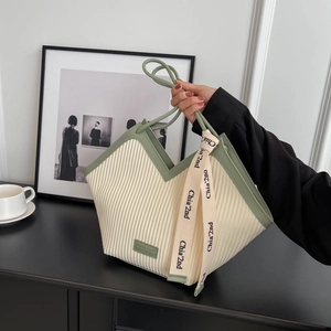 Vertical pleated tote bag with heart-shaped design and contrasting green leather handles