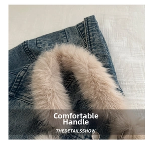 Detail of soft beige faux fur handle and blue washed denim fabric with metal button