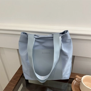 Minimalist light blue tote bag for women with spacious front pocket and woven handles
