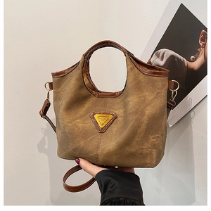 Close-up of retro brown canvas bag with leather trim and triangle logo detail