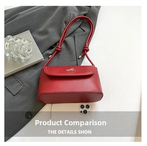 Detail view of red faux leather shoulder bag with golden bow and rope knot strap