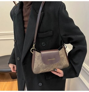 Dettaglio della borsa a tracolla in pelle marrone con patta vintage e fibbie dorate