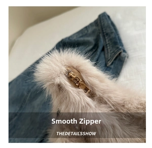 Close-up of smooth gold metal zipper on fluffy beige plush shoulder bag for women