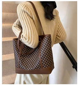 Close-up of geometric pattern texture and leather strap on a brown tote bag