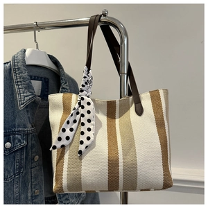 Detail view of large canvas tote bag with brown stripes and polka dot silk scarf handle