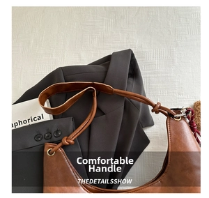 Detailansicht einer braunen Ledertasche mit Knotengurt und matter Litschikorn-Textur