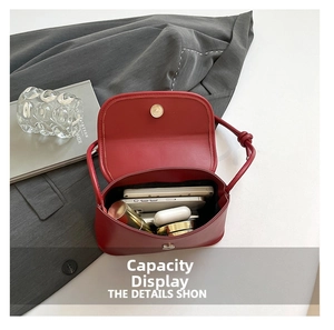Internal storage view of a red saddle shoulder bag showing spacious capacity for items