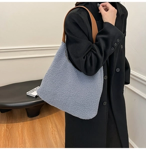 Blue fleece tote bag with brown leather straps shown over a black winter wool coat